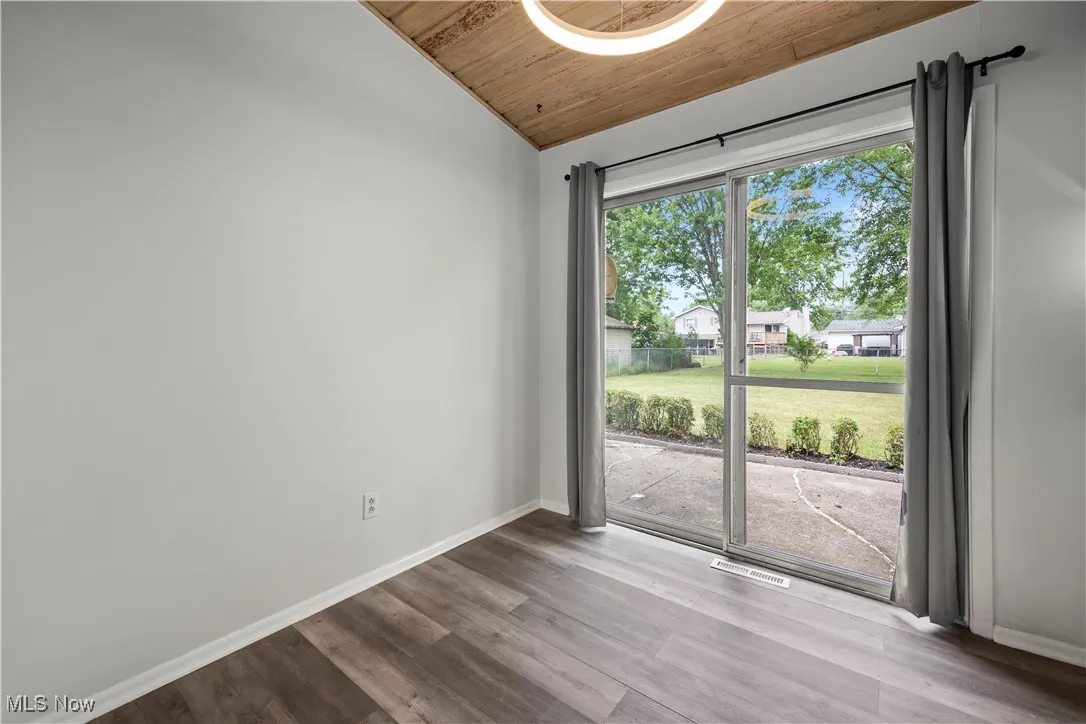 Unfurnished room featuring vaulted ceiling, wooden ceiling, and wood finished floors