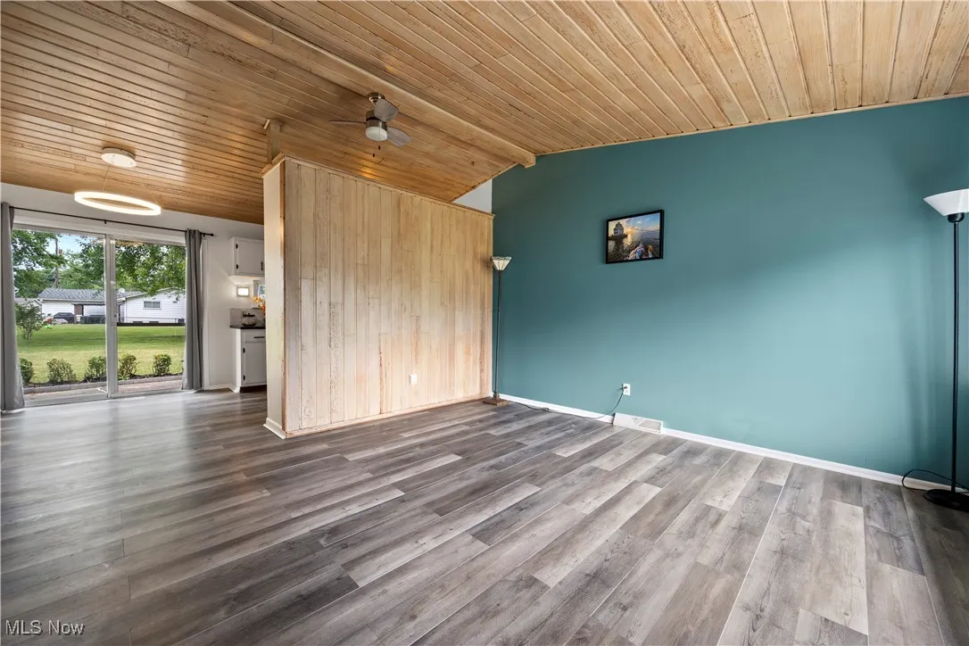Unfurnished living room with wooden ceiling, vaulted ceiling, a ceiling fan, and wood finished floors