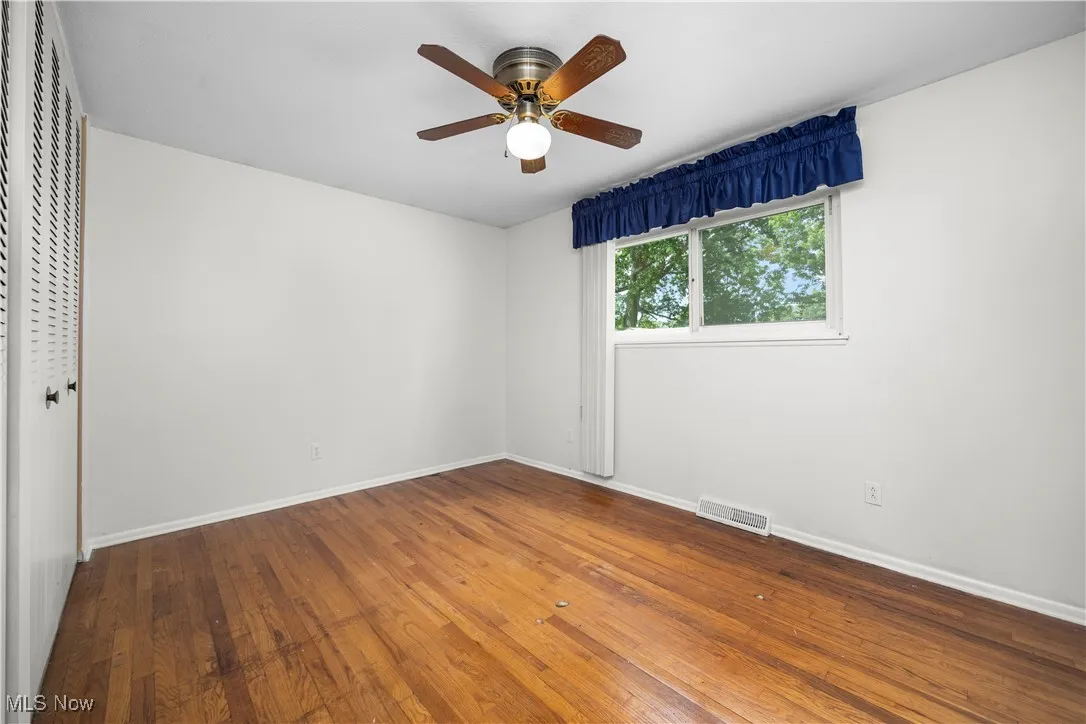 Unfurnished bedroom with wood-type flooring, a closet, and ceiling fan
