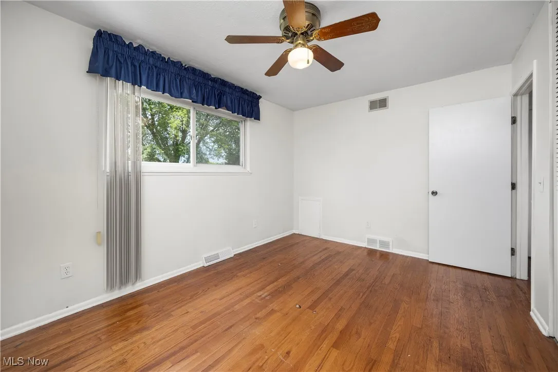 Unfurnished bedroom with ceiling fan and hardwood / wood-style floors