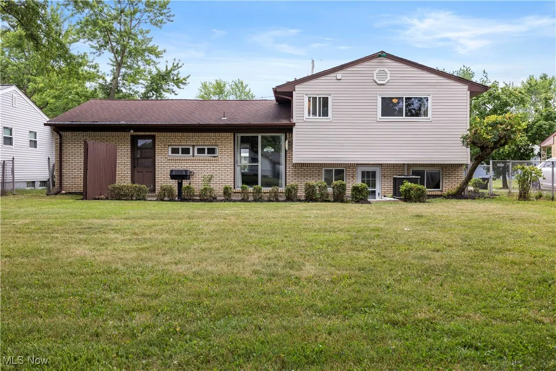 Split level home featuring brick siding and a front yard