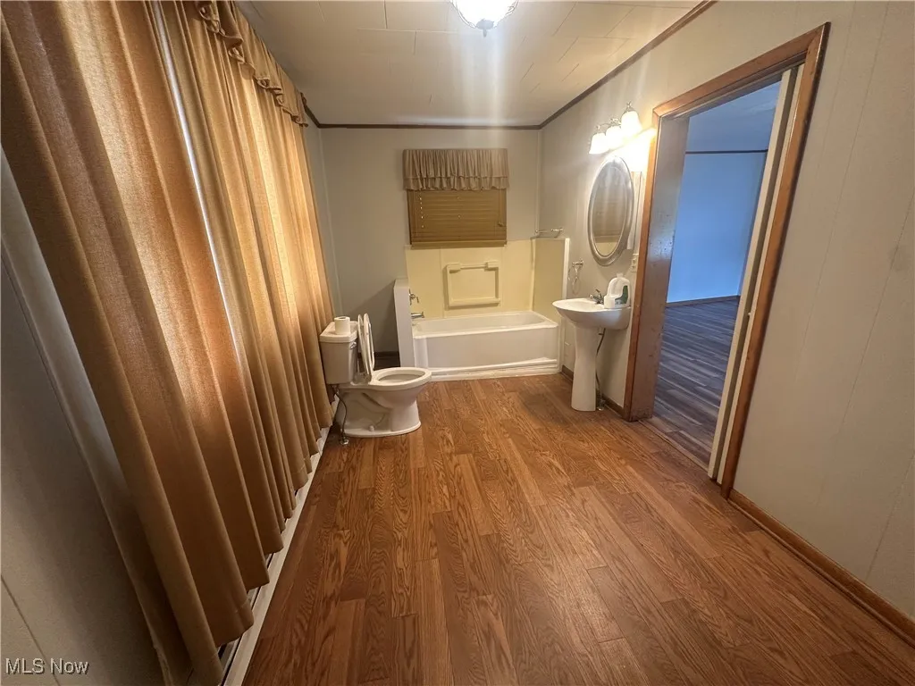 Bathroom featuring wood finished floors, a bathtub, and a shower