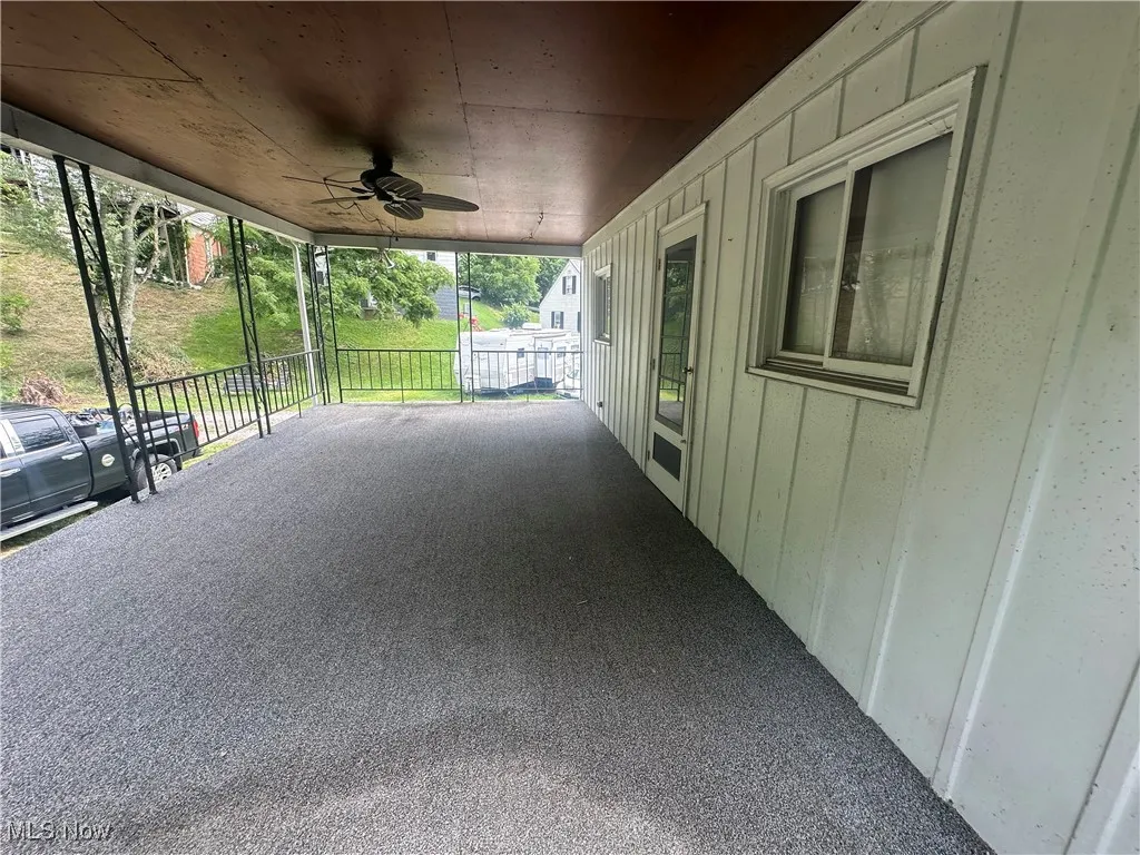 Covered porch featuring a carport and a ceiling fan