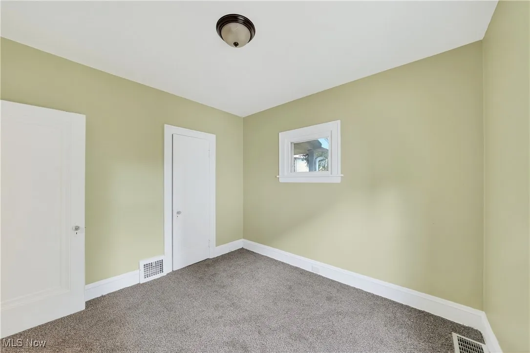 Unfurnished bedroom with carpet floors and baseboards