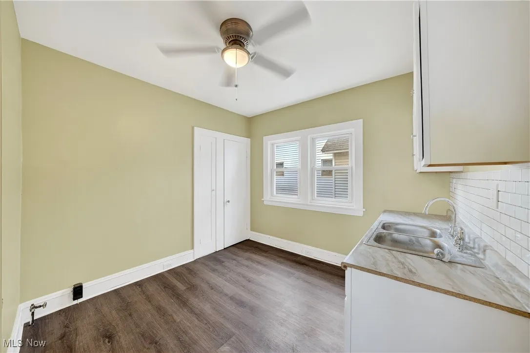 Laundry area with dark wood-style floors and ceiling fan
