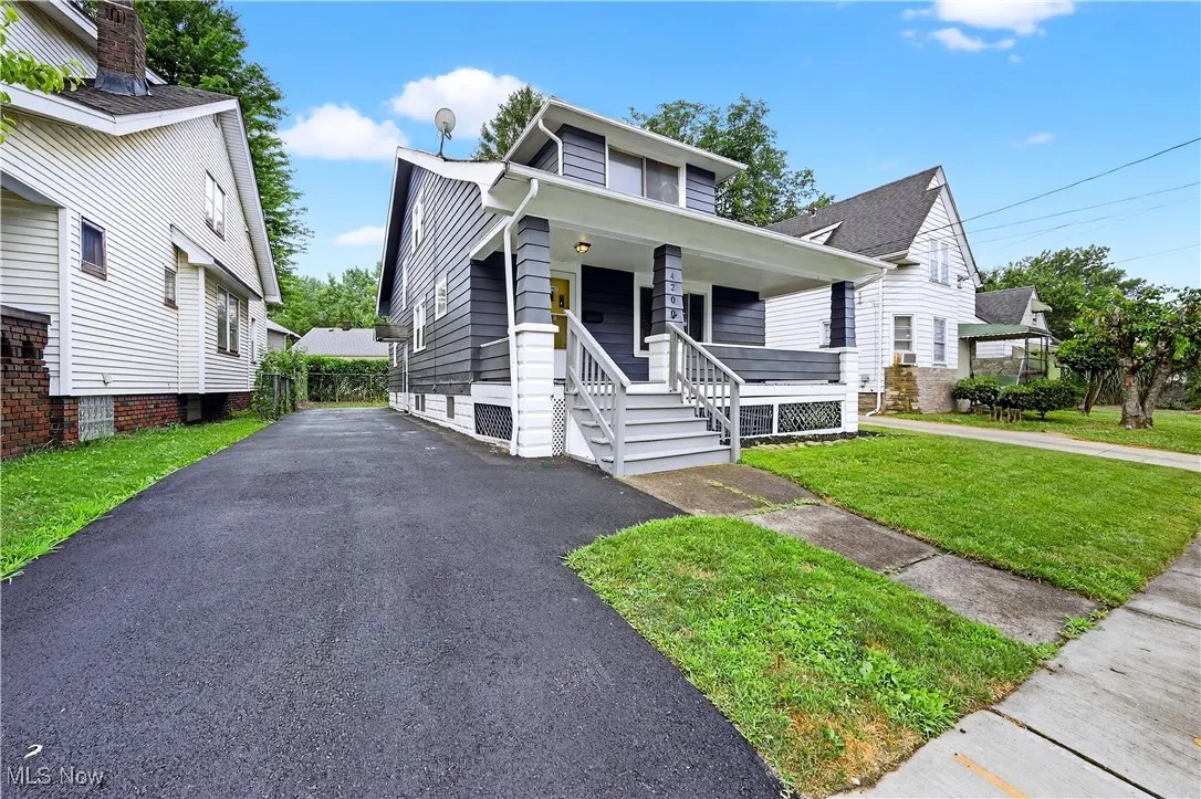 View of front of house featuring covered porch, a front yard, and driveway