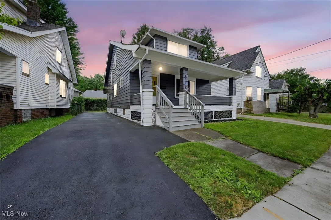 View of front facade featuring covered porch, a front lawn, and driveway