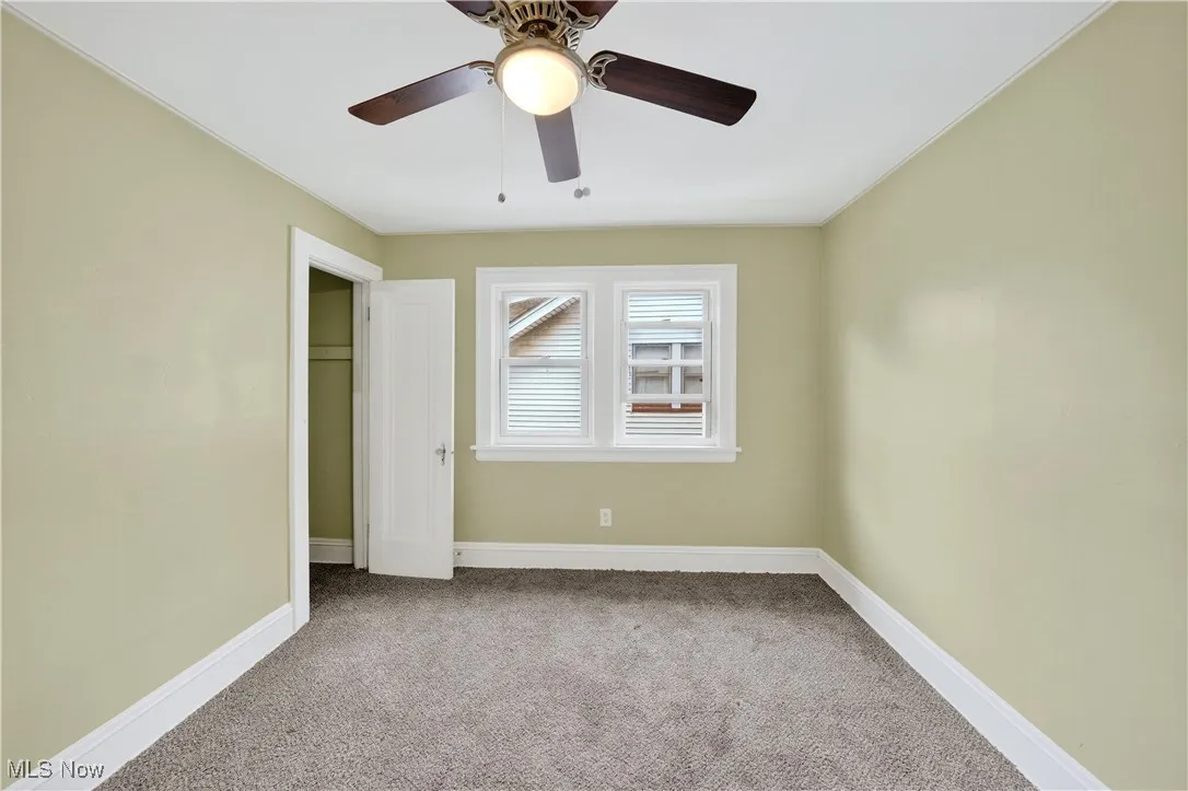 Unfurnished bedroom featuring carpet flooring, a ceiling fan, and ornamental molding