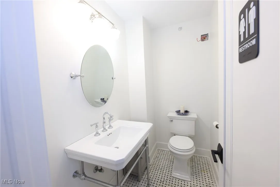 Half bathroom with toilet and baseboards