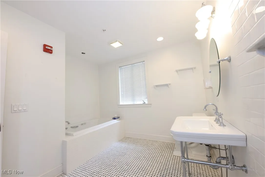 Full bath with a bath and baseboards