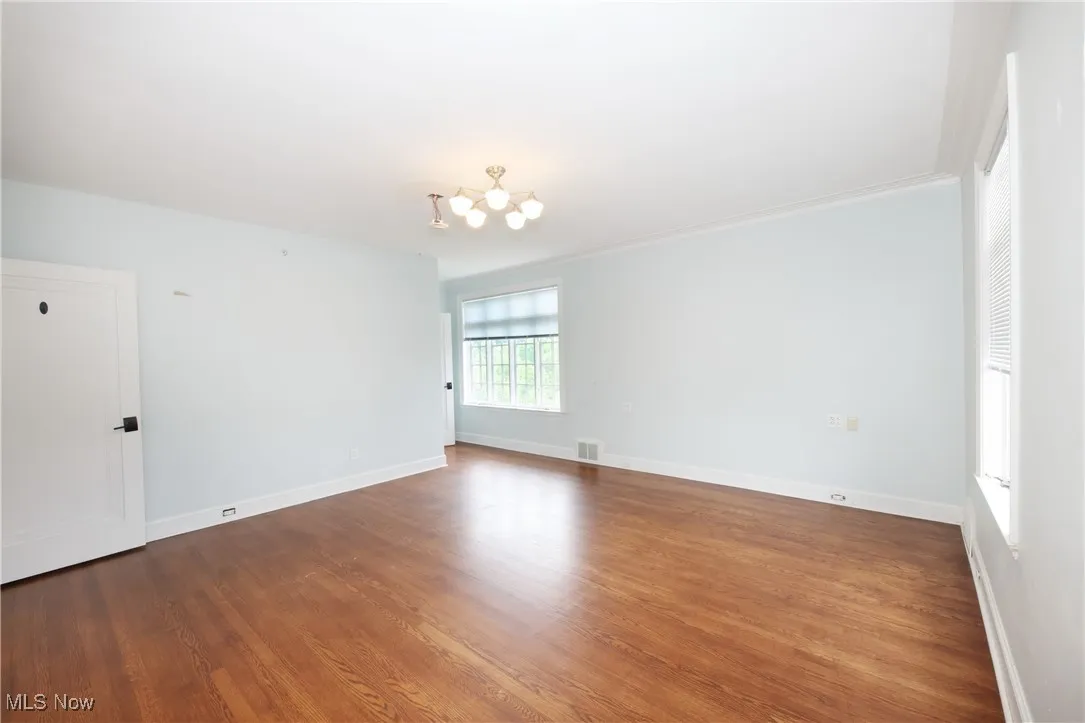 Empty room with a chandelier and wood finished floors