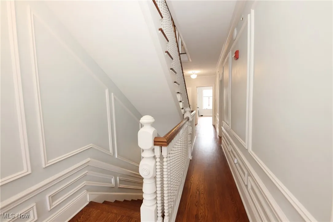 Hall featuring a decorative wall and wood finished floors