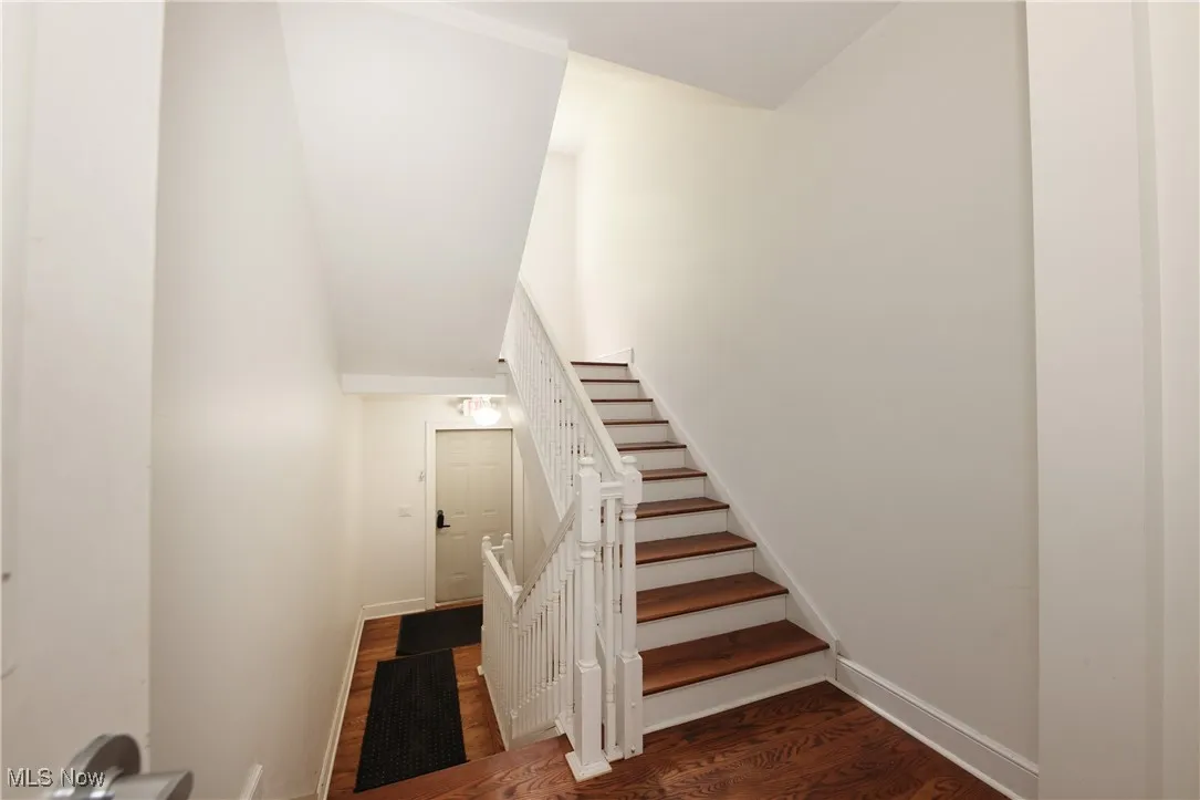 Stairs featuring wood finished floors and baseboards