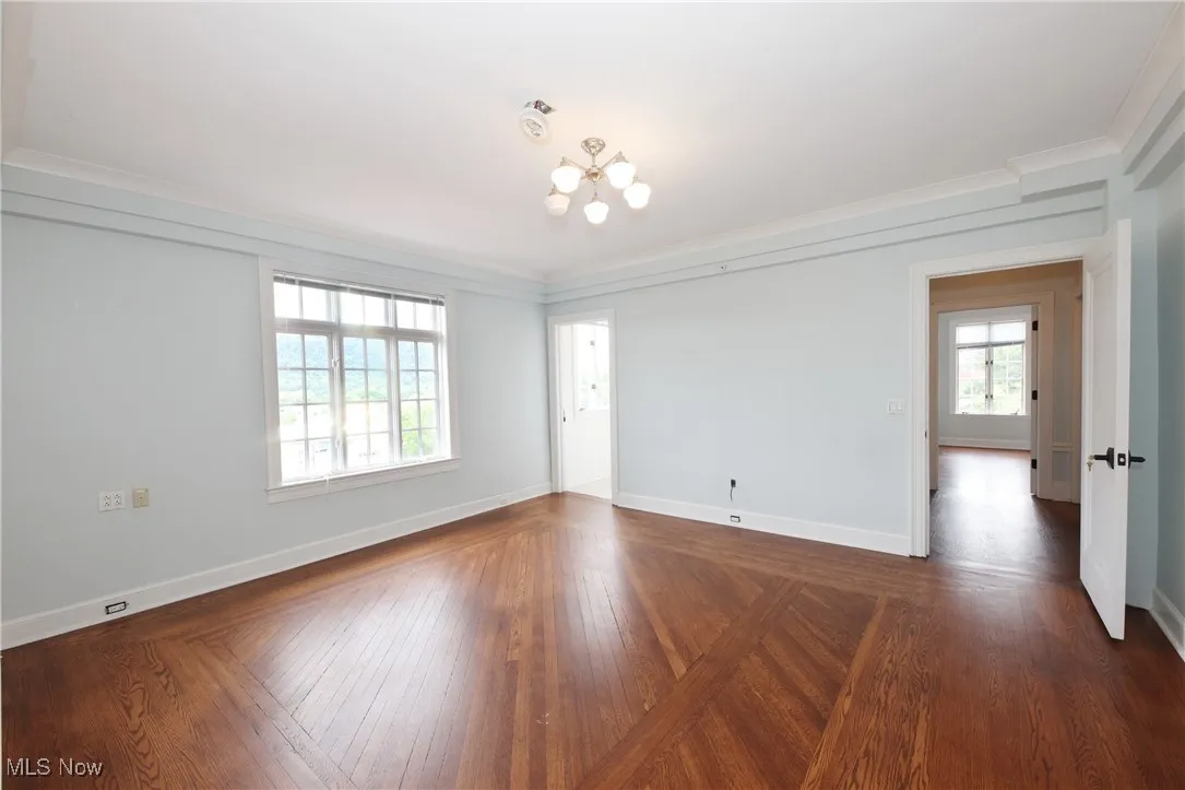 Spare room featuring a chandelier and ornamental molding