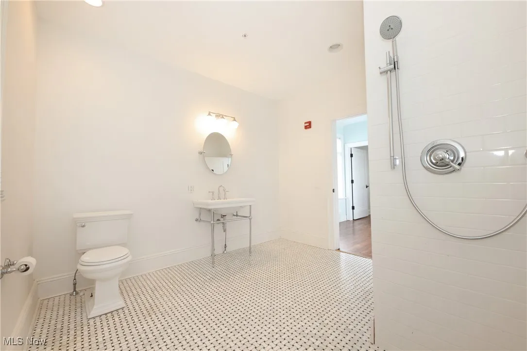 Full bath with tiled shower and tile patterned floors
