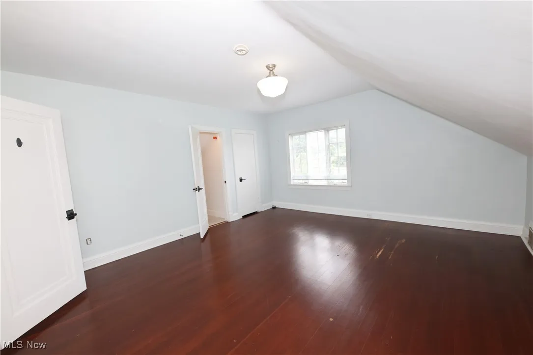 Additional living space featuring wood finished floors and lofted ceiling