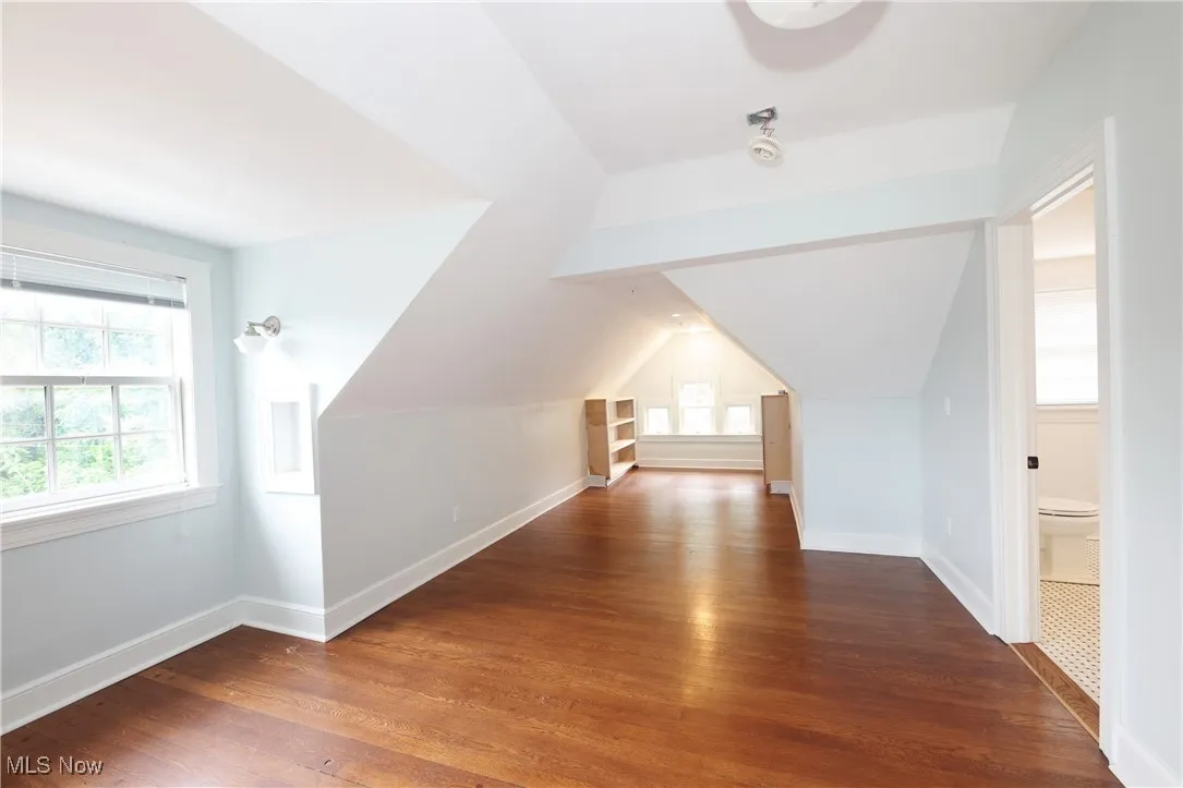 Bonus room with wood finished floors and vaulted ceiling