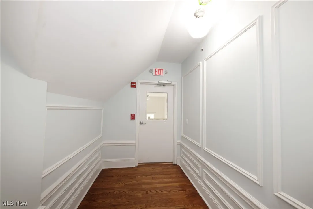 Hall with vaulted ceiling and wood finished floors