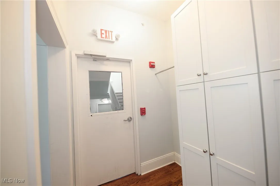 Hallway with dark wood-style flooring and baseboards