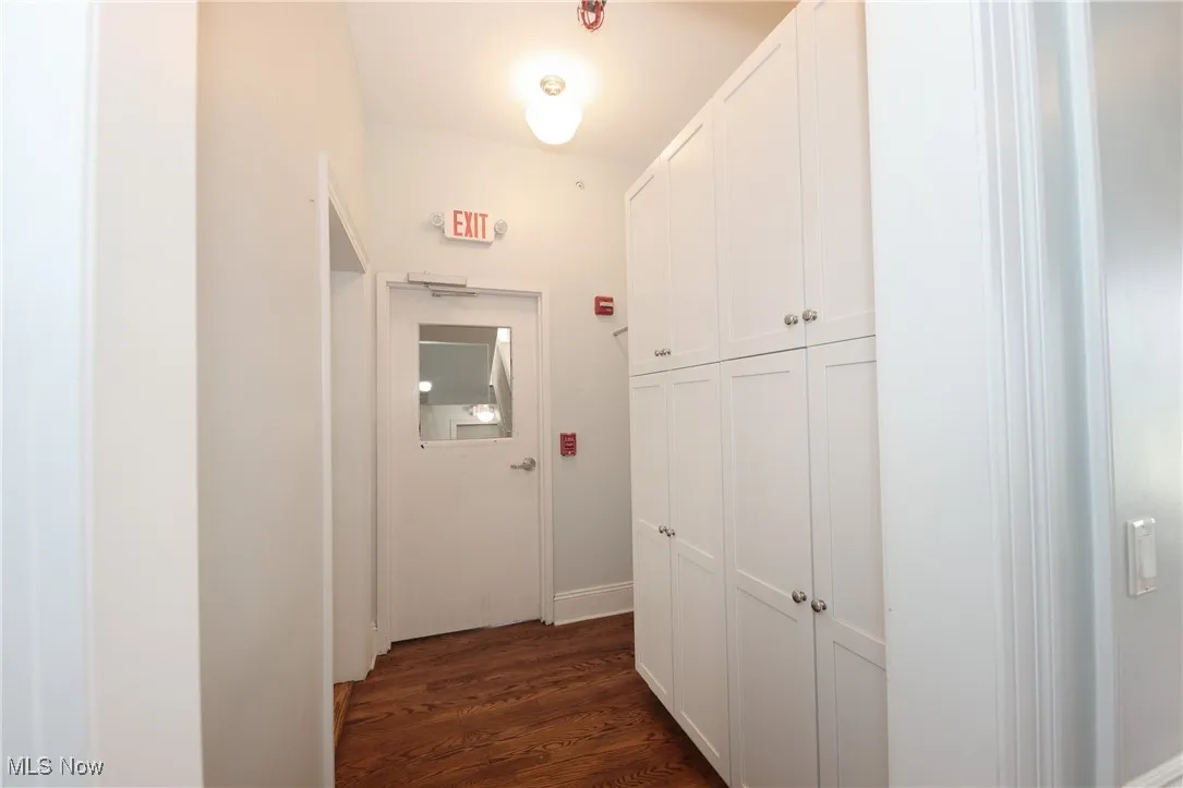 Corridor featuring dark wood-style flooring