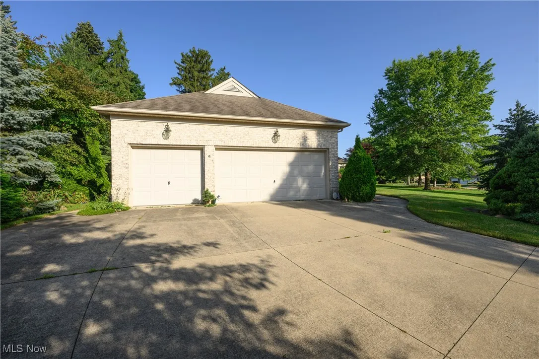 View of property exterior with a garage and concrete driveway