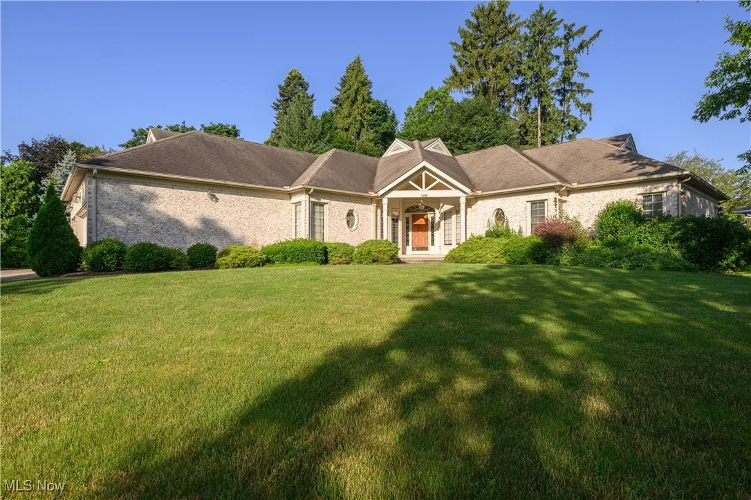 Cape cod home with a front yard and brick siding