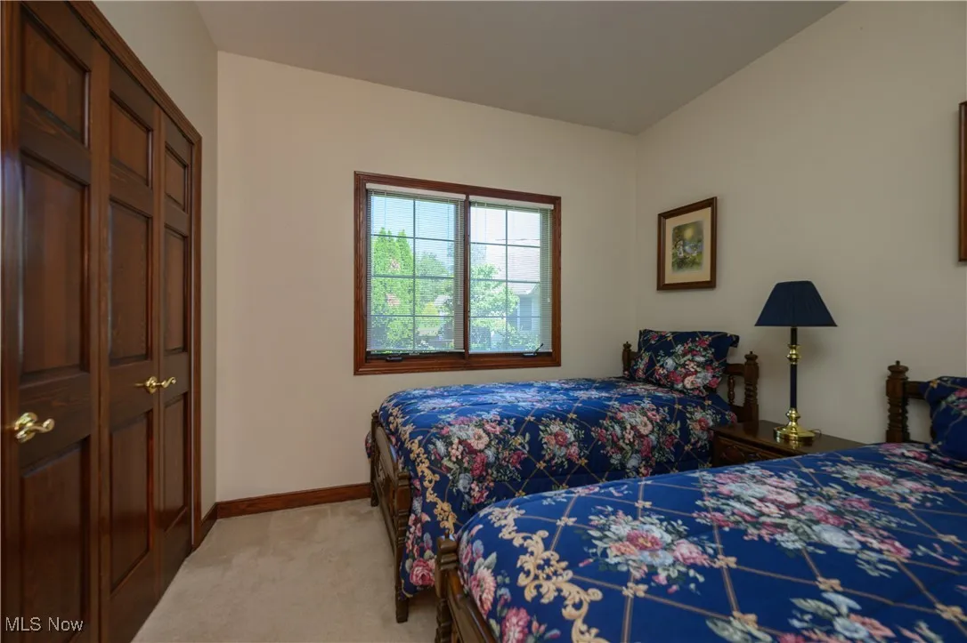 Bedroom featuring light carpet and baseboards