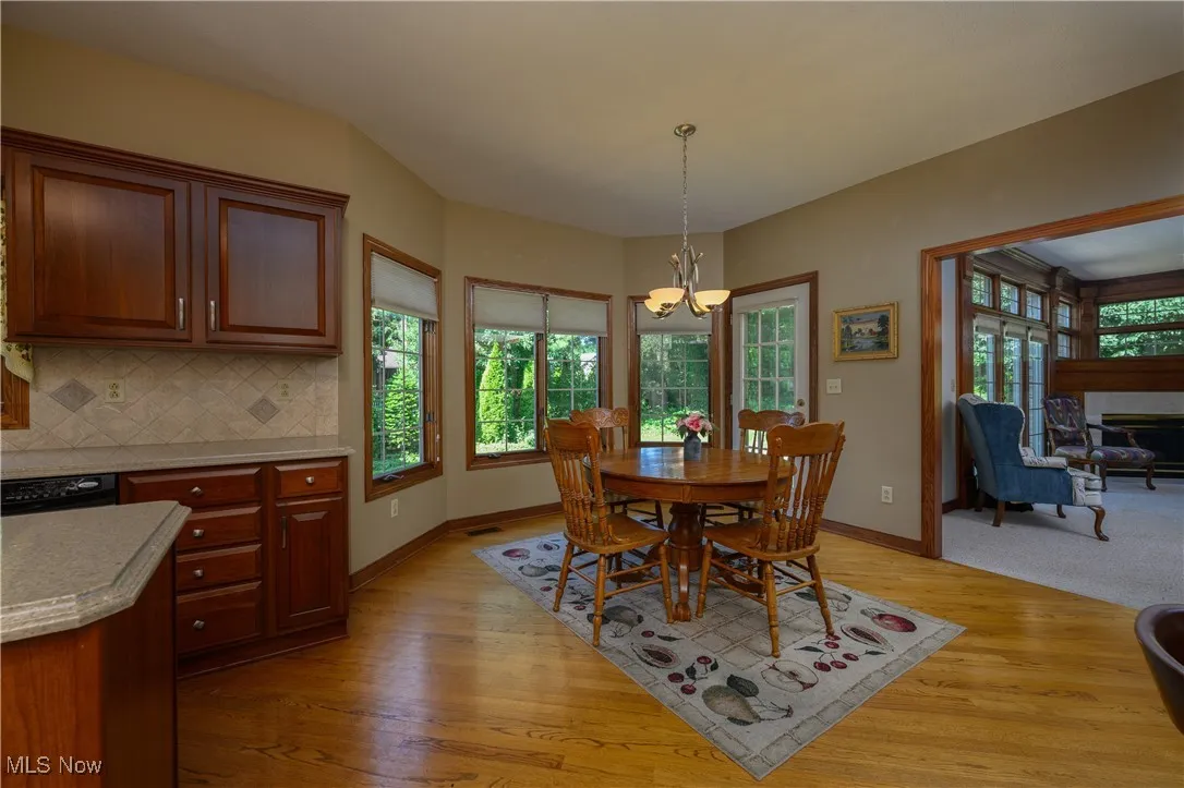Dining space with a chandelier, light wood-style floors, and a fireplace