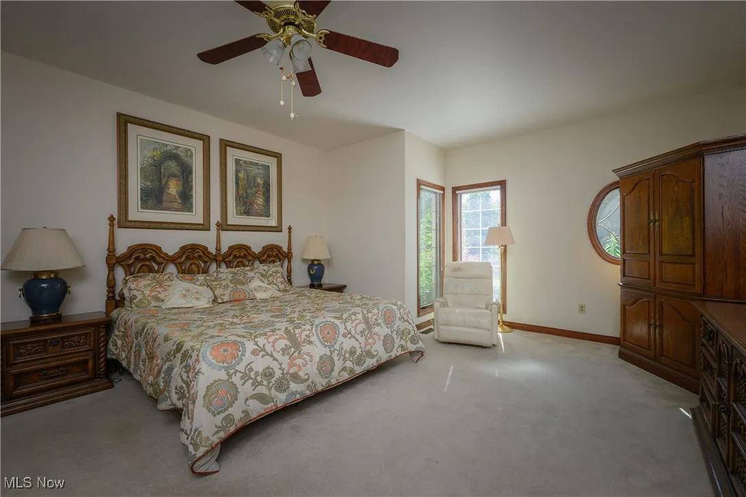 Carpeted bedroom featuring baseboards and a ceiling fan