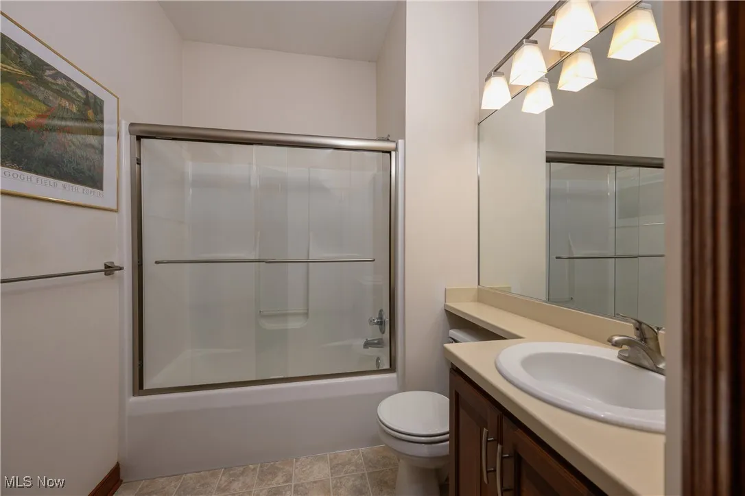 Bathroom with vanity and enclosed tub / shower combo