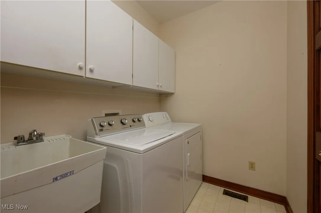 Washroom featuring cabinet space and independent washer and dryer