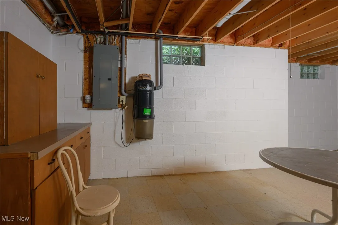 Below grade area with electric panel and tile patterned floors