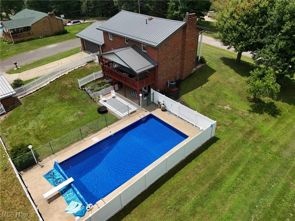 View of swimming pool featuring a wooden deck and a fenced backyard