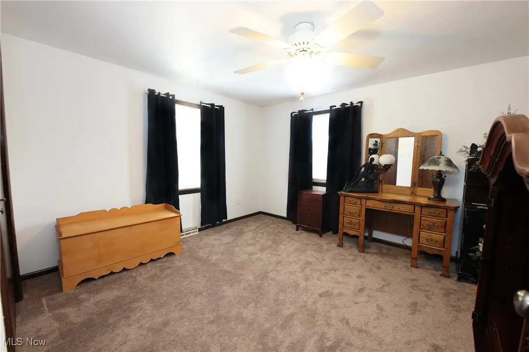 Carpeted bedroom with a ceiling fan