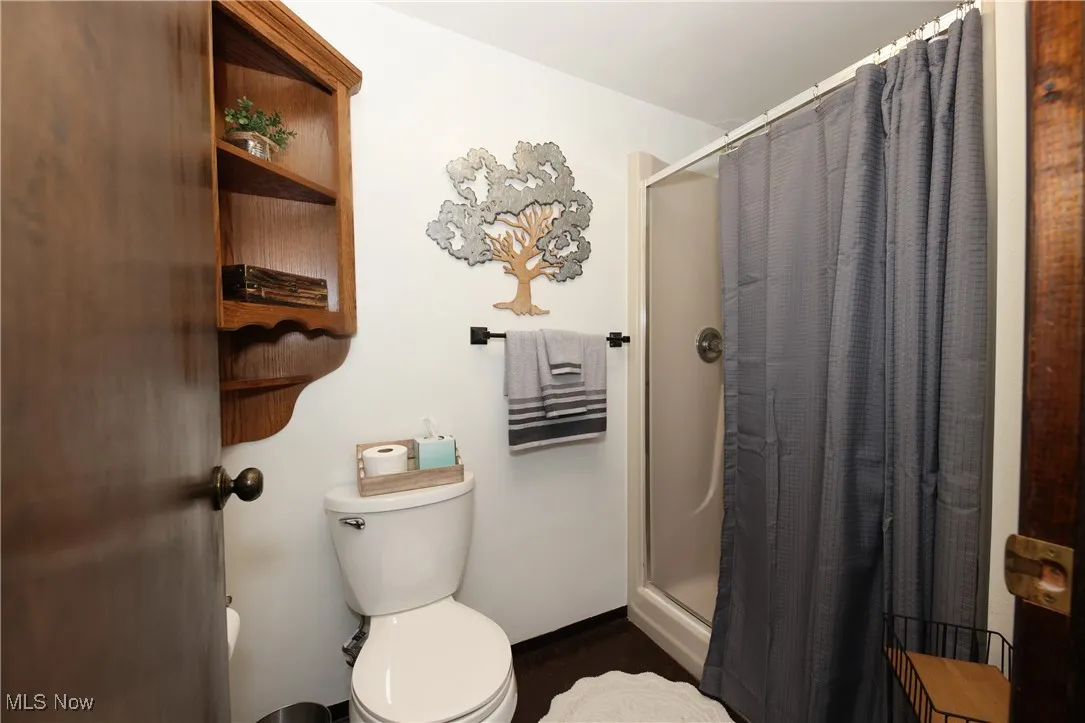 Bathroom featuring toilet and a stall shower