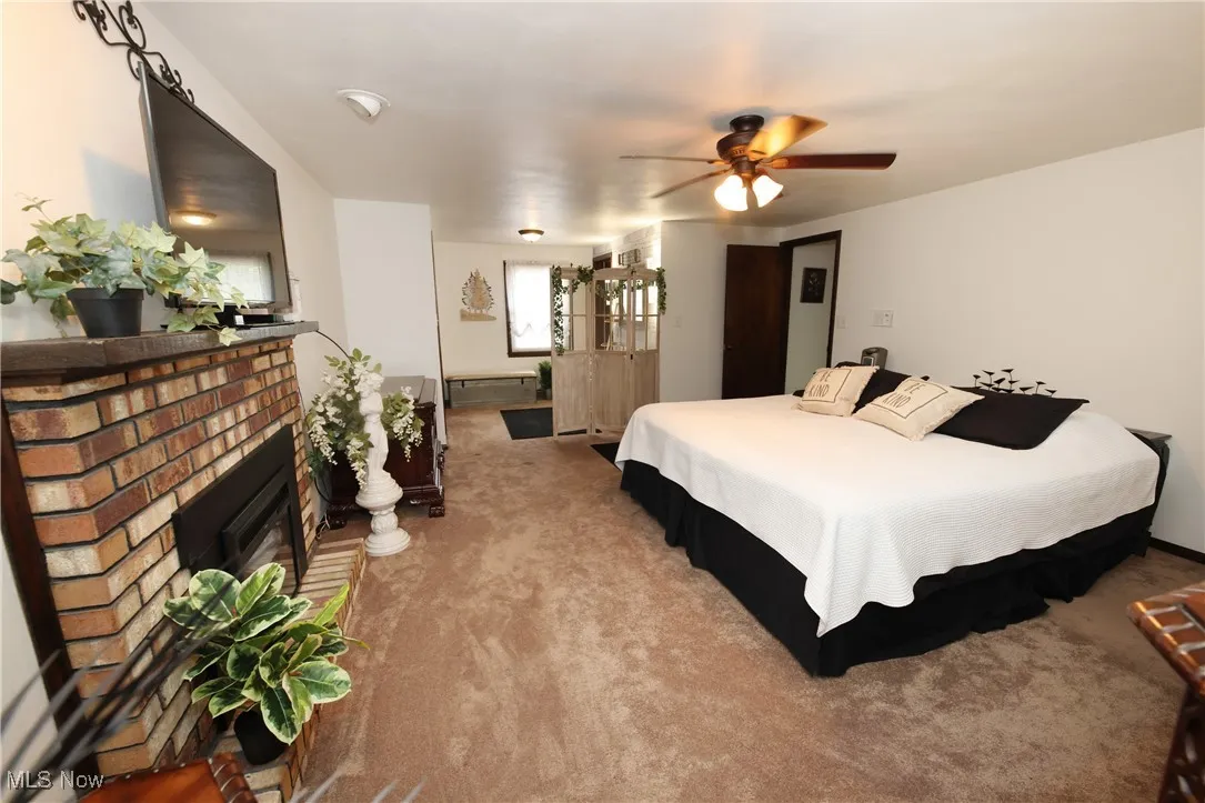 Bedroom featuring carpet flooring and a brick fireplace