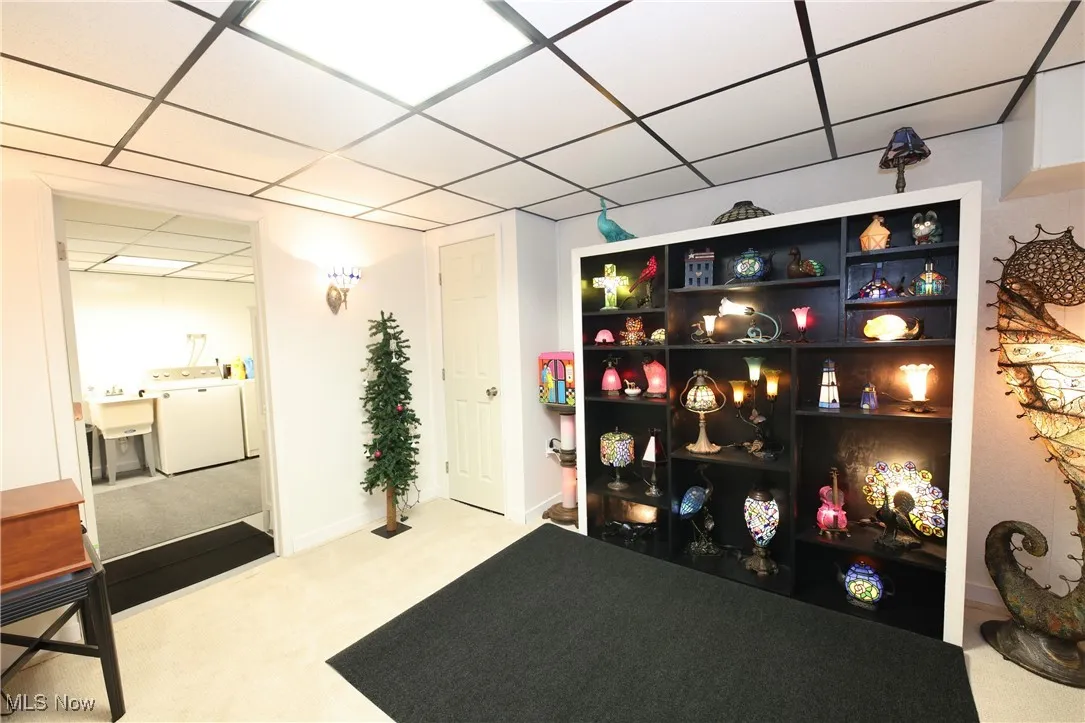 Miscellaneous room with washer / dryer, a paneled ceiling, and carpet flooring