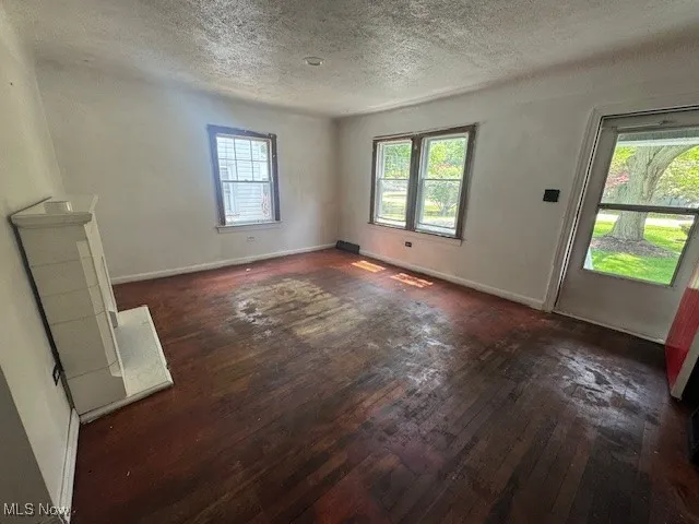 Unfurnished room featuring hardwood / wood-style flooring and a textured ceiling