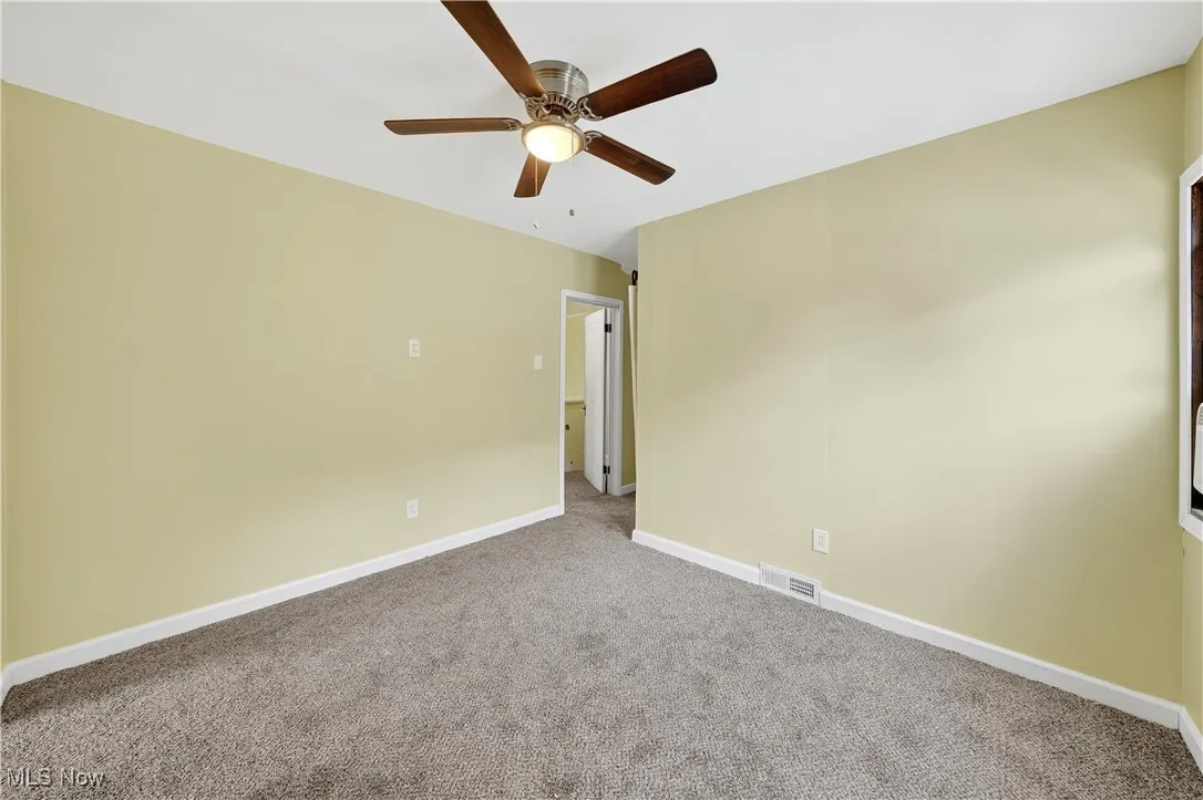 Empty room featuring carpet and ceiling fan