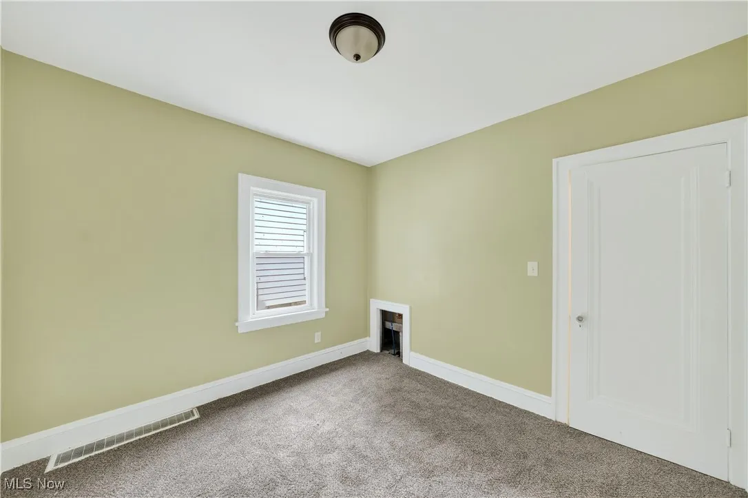 Carpeted empty room with baseboards