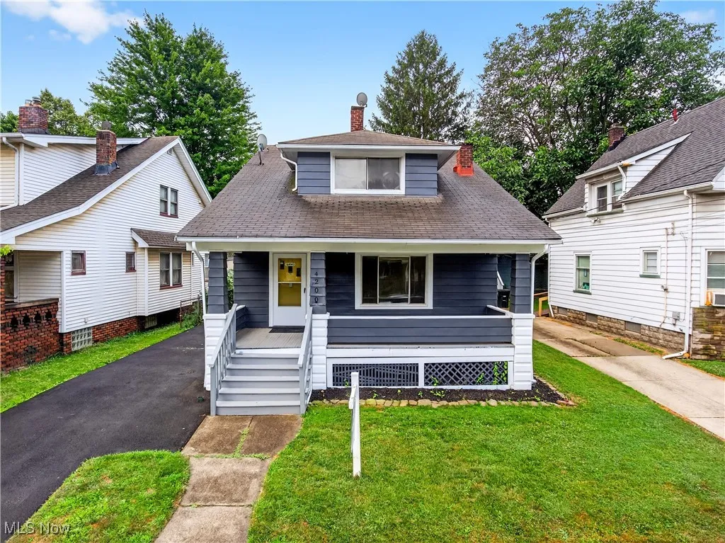 Bungalow-style house with a porch, a front lawn, a chimney, and a shingled roof