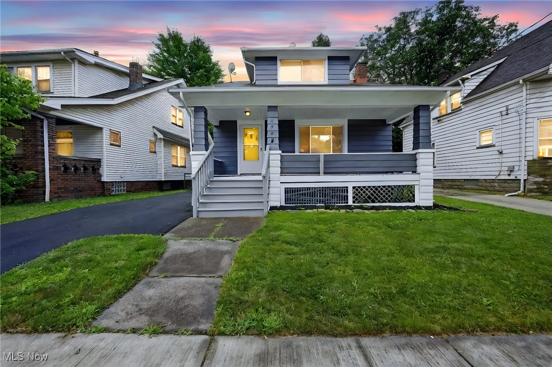 View of front of property with covered porch and a front yard