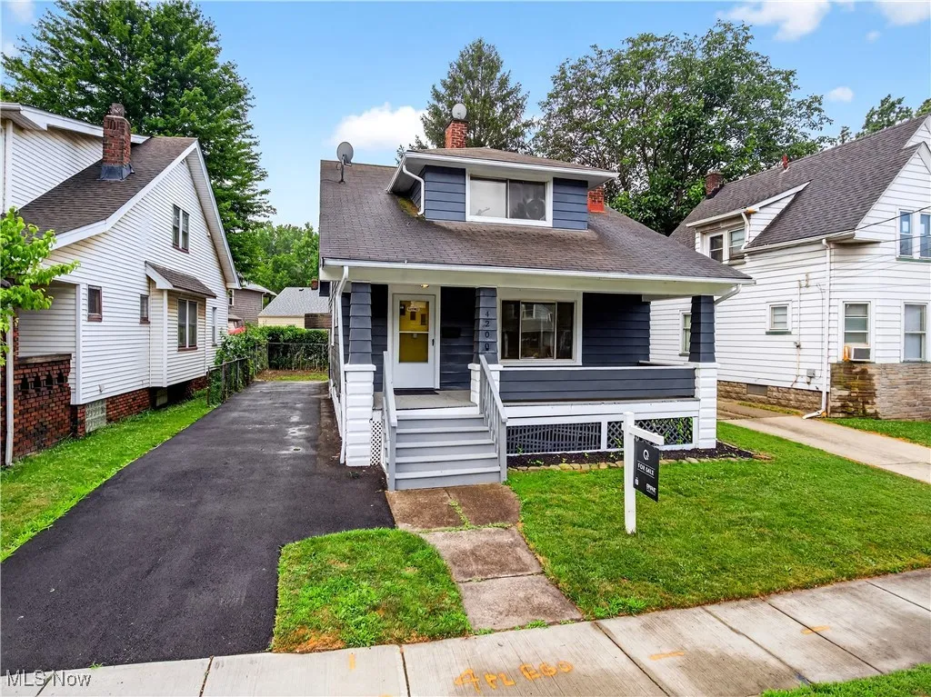 Bungalow featuring a porch, a front lawn, a shingled roof, and a chimney