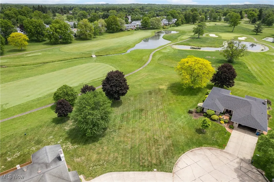 Drone / aerial view of a nearby body of water and a golf club