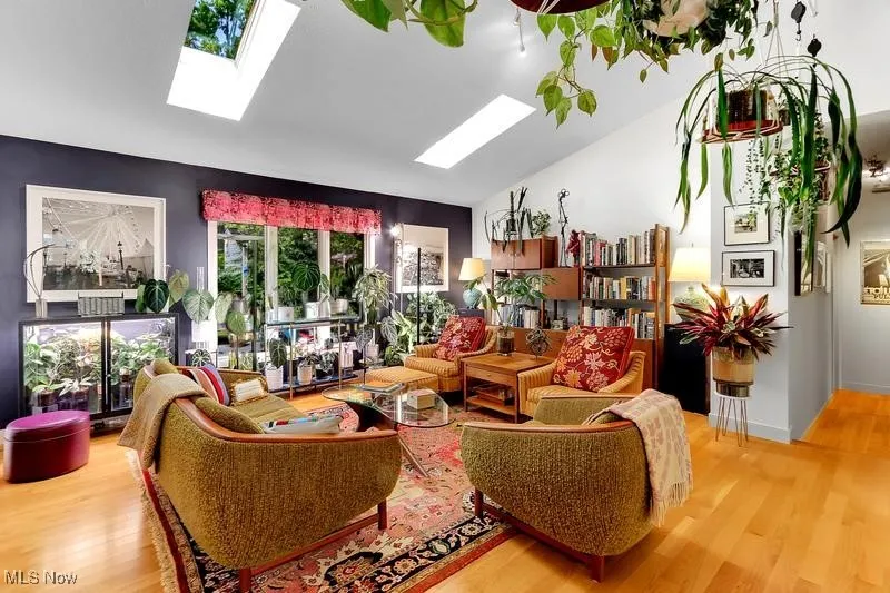 Vaulted, skylighted living room with 2 seating areas overlooks the deck/backyard.