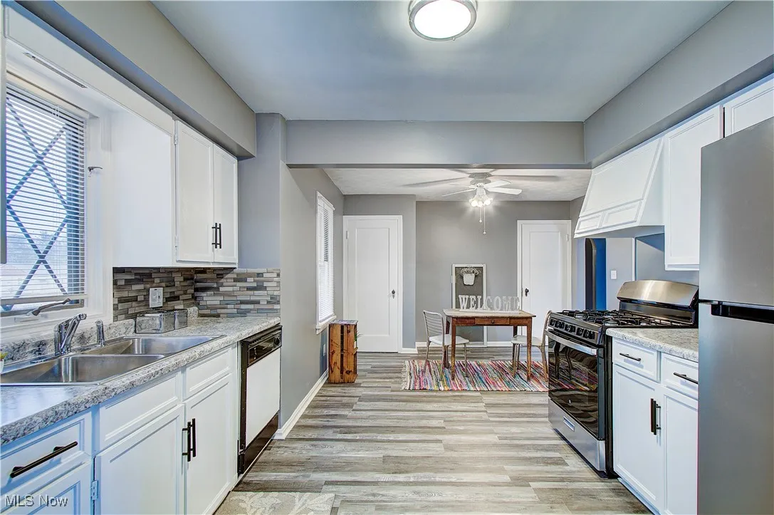 Roomy kitchen with new counter tops and backsplash.