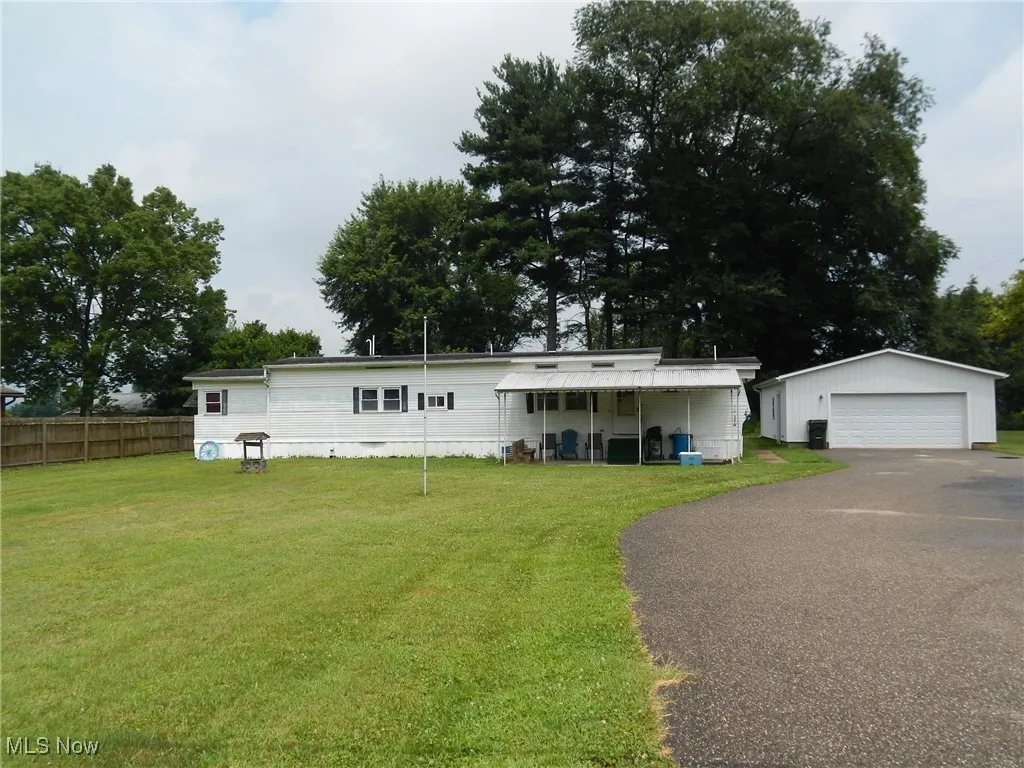 Manufactured / mobile home with a detached garage and an outbuilding