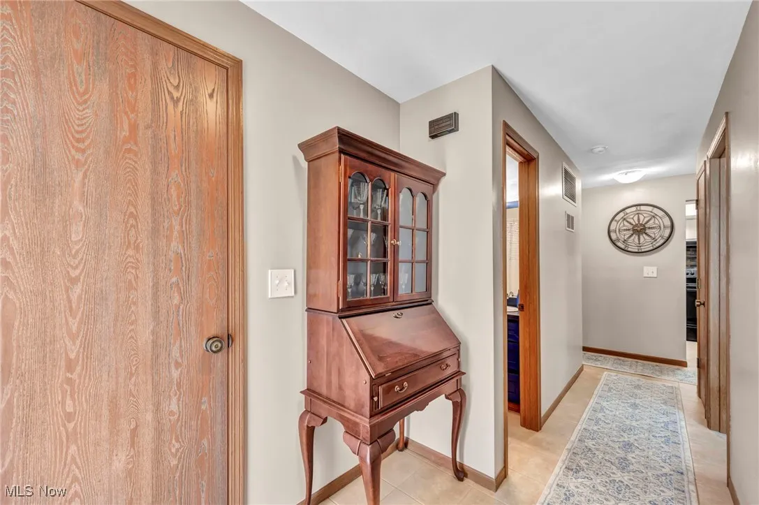 Hallway with baseboards and light tile patterned floors