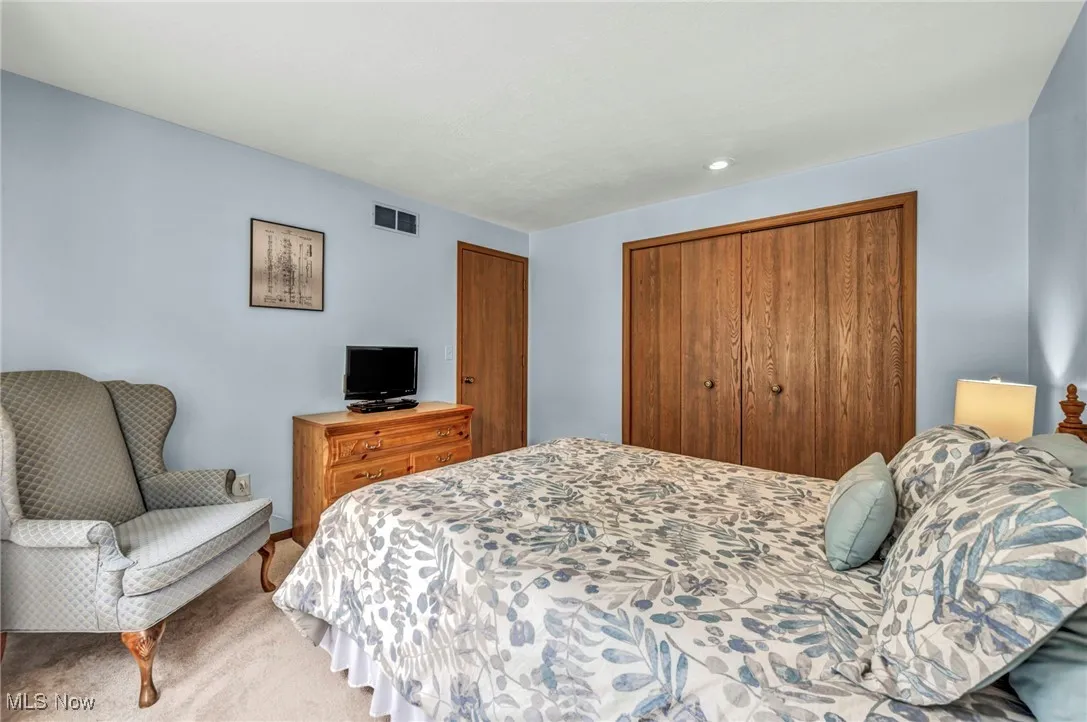 Bedroom featuring a closet, light colored carpet, and recessed lighting
