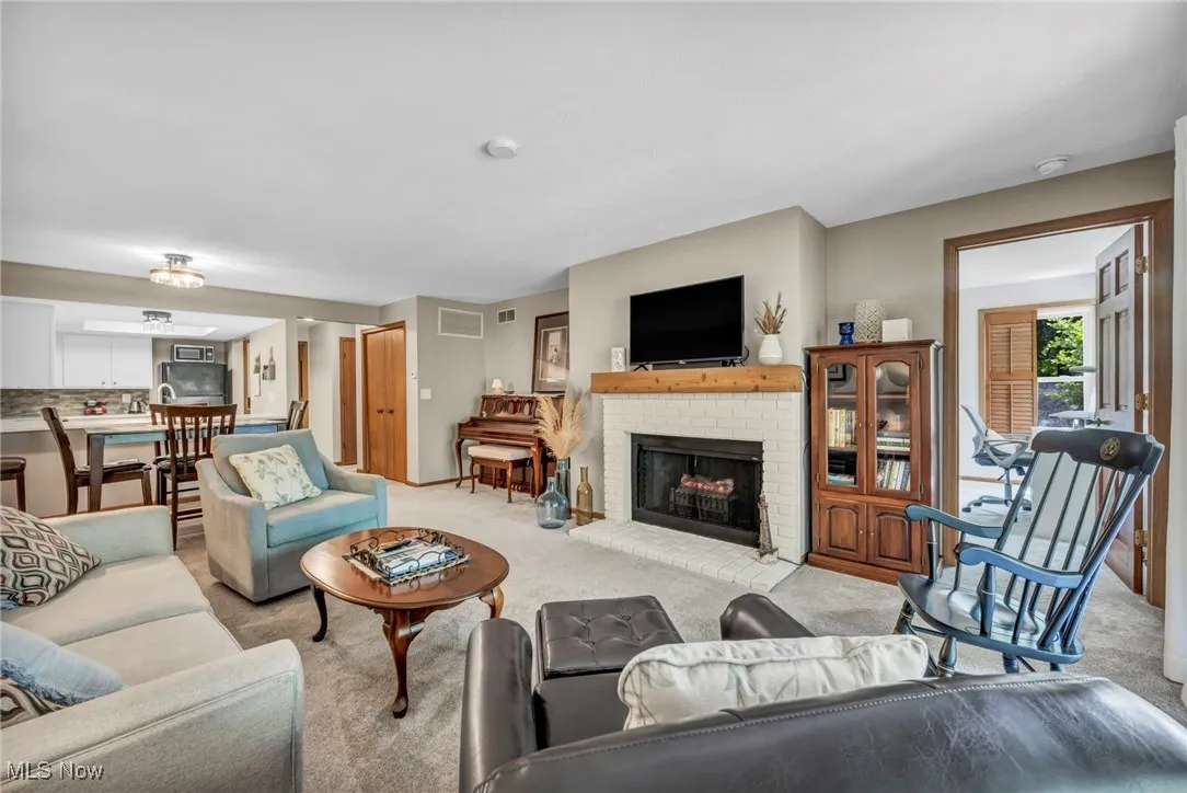 Living room featuring light carpet and a fireplace